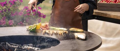 A chef grilling vegetables outdoors.