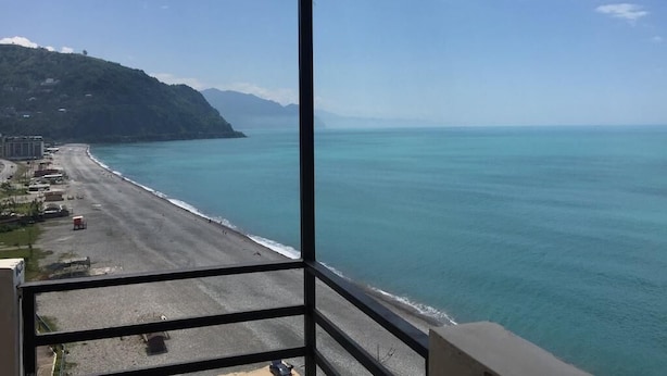 Ein Balkon mit Blick auf Strand und Meer.