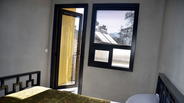 A bedroom with a bed, a window, and a door. - Ephesus Hostel (Selçuk)