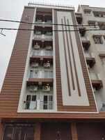 Un edificio de varios pisos con diseño moderno, que cuenta con balcones con unidades de aire acondicionado, un panel de madera vertical destacado y un cartel que dice “The Grace”.