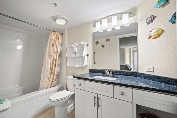Baño con ducha, inodoro, lavabo y armarios.