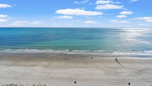Ein Strand mit blauem Himmel und ruhiger See.