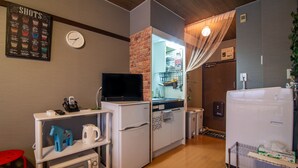 A compact kitchen with a microwave, refrigerator, and a small TV on a stand. - A0 Kinshichou 202 (Tokyo)