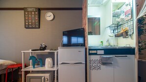 A compact kitchenette with a microwave, refrigerator, and a small TV on a stand. - A0 Kinshichou 202 (Tokyo)
