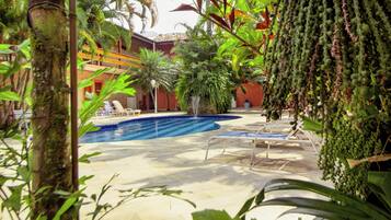 Una piscina al aire libre, sillones reclinables de piscina