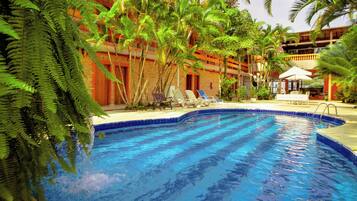 Una piscina al aire libre, sillones reclinables de piscina