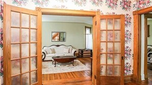 Un salon avec un plancher en bois, un canapé blanc et une table basse.