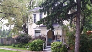 Une maison à deux étages avec un porche, une boîte aux lettres et une pelouse bien entretenue.