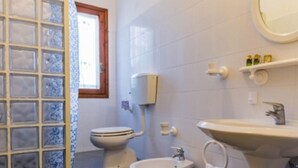Et badeværelse med toilet, bidet og vask.