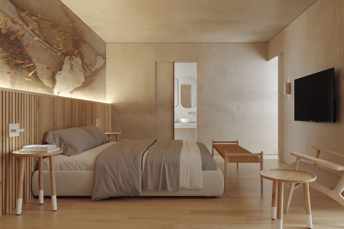 A modern bedroom with a bed, bedside table, chair, and a TV.