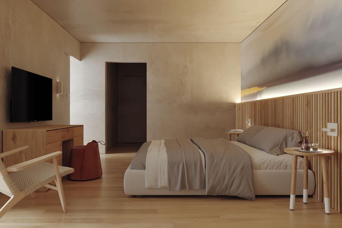 A modern bedroom with a wooden desk, a television, a bed with a headboard, a bedside table, and a chair.