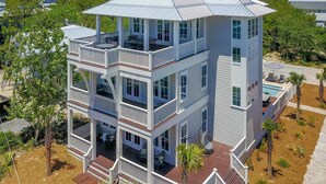 Un edificio de varios pisos con balcones, piscina y jardín ajardinado.