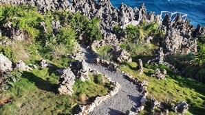 A coastal landscape with a rocky path leading to a cliff overlooking the ocean. - West Bay Suite  (King Suite) (West Bay)
