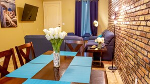A dining area with a wooden table, blue placemats, and a vase of white flowers. - Chicago Style Town home in a gated community!!Spacious 1100sqft (Edinburg)