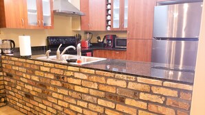 A kitchen with a brick backsplash, stainless steel appliances, and wooden cabinets. - Chicago Style Town home in a gated community!!Spacious 1100sqft (Edinburg)