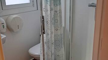 Eenvoudige tweepersoonskamer | Badkamer | Een douche, handdoeken