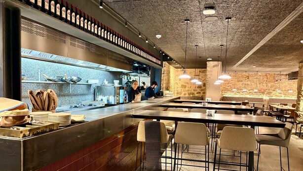 A restaurant with a bar area, tables, and chairs. - Hostal Bearan (Pamplona)