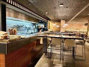 A restaurant with a bar area, tables, and chairs. - Hostal Bearan (Pamplona)