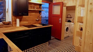 A compact kitchen with a black sink, wooden cabinets, and a checkered floor. - Hausele holiday apartment (Sulzbach an der Murr)