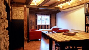 A cozy room with a wooden table, red sofas, and a stone wall. - Hausele holiday apartment (Sulzbach an der Murr)