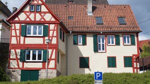 A traditional half-timbered house with a red-tiled roof and green shutters. - Hausele holiday apartment (Sulzbach an der Murr)
