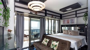 A modern bedroom with a large bed, a sofa, and a glass table. - 360 República (São Paulo)
