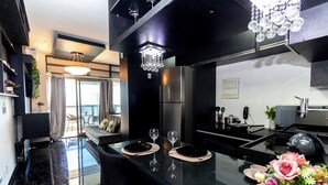 A modern kitchen with a glass dining table, stainless steel appliances, and a chandelier. - 360 República (São Paulo)