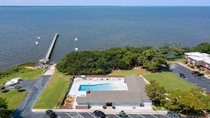 Eine Vogelperspektive eines Hotels mit Schwimmbad, Parkplatz und Blick auf das Meer.