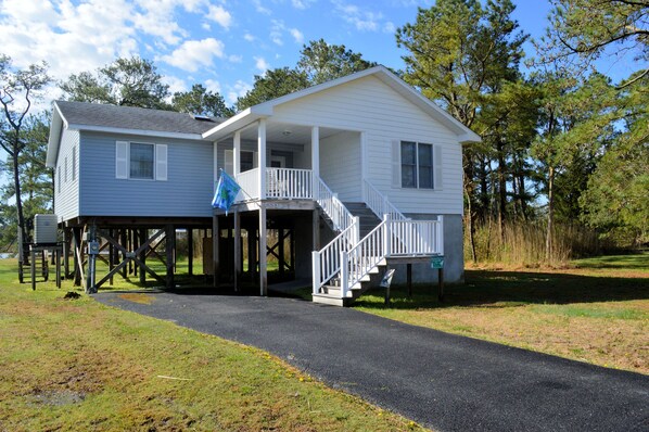 A two-story house with a covered porch and a staircase leading to the second floor.
