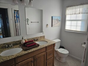 A bathroom with two sinks, a toilet, and a shower curtain.