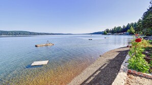 A calm lake with clear water, a wooden dock, and a pebble beach. - Hood Canal waterfront five bedrooms hottub watercrafts boat launch Olympic view (Belfair)