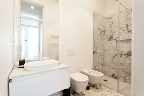 A modern bathroom with a white sink, toilet, and shower. - FLH Restauradores Bright Flat (Lisbon)