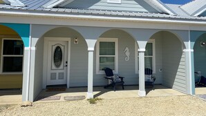 A house with a gabled roof, a covered porch with three columns, and a small window above the door. - 2BR/2BA - Availability now! 
- Clean
- Close to the beach
 - Sleeps 6 (Mexico Beach)
