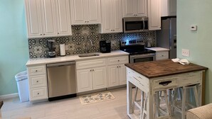 A kitchen with white cabinets, a microwave, stove, and a coffee maker. - 2BR/2BA - Availability now! 
- Clean
- Close to the beach
 - Sleeps 6 (Mexico Beach)