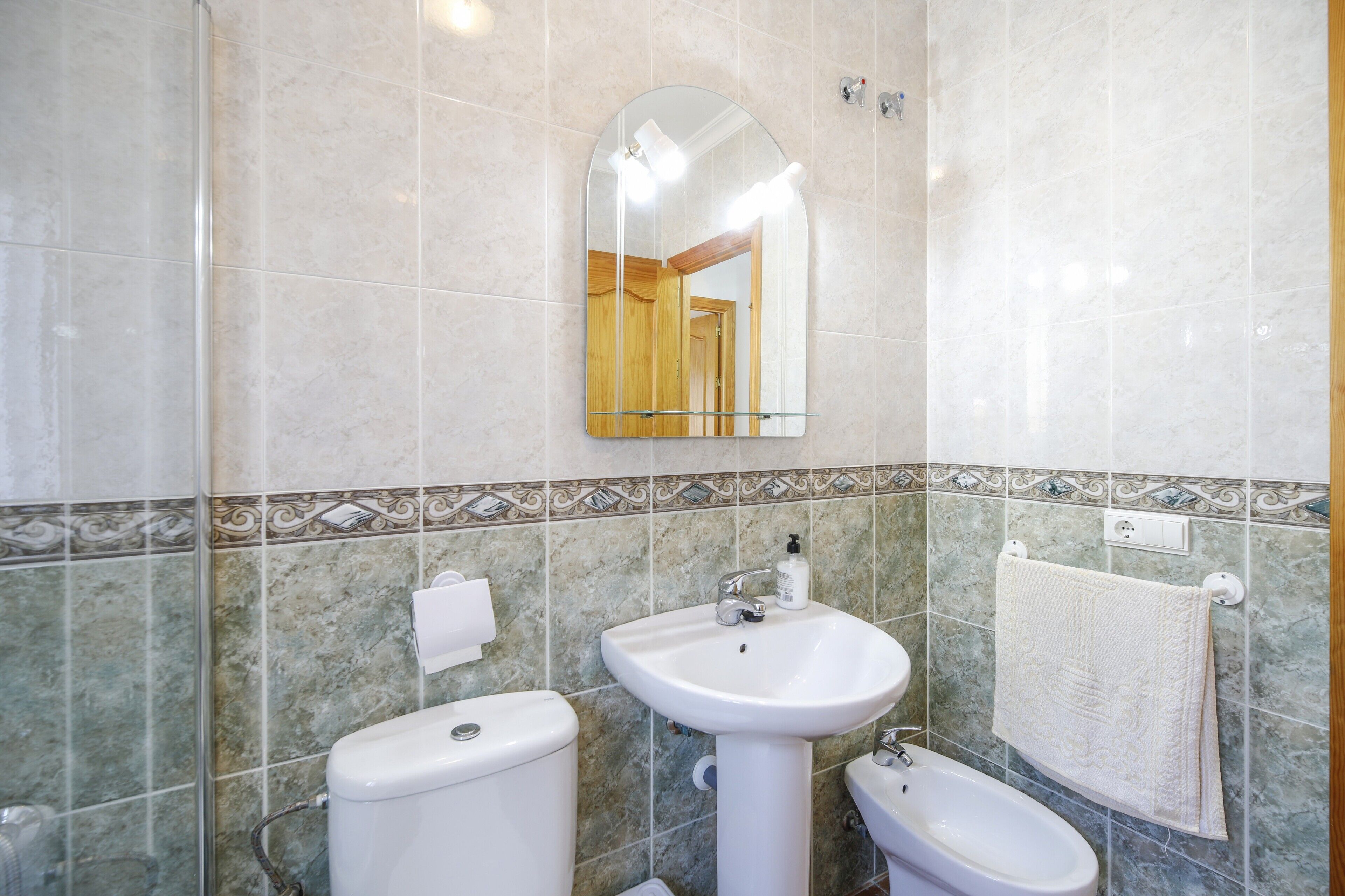 A bathroom with a toilet, a sink, and a bidet.