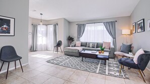 Una sala moderna con un sofá gris, una mesita de centro y una alfombra estampada.