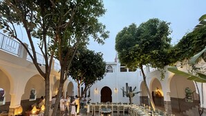 An outdoor dining area with tables and chairs, a central fountain, and trees. - LA SIESTA, 18 rooms, 41 sleeps for your event in Marrakech (Marrakech)