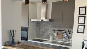 A modern kitchen with a wooden countertop, black chairs, a stainless steel range hood, and a tiled backsplash. - Luxury Travel Station - Pula (Pula)