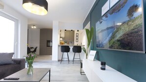 A modern living room with a sofa, coffee table, and a painting of a scenic landscape. - Luxury Travel Station - Pula (Pula)