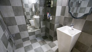 A modern bathroom with a large mirror, a white sink, and a shower area. - Number 25 Gongju Shingwan (Gongju)