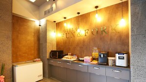 A hotel reception area with a counter, a refrigerator, a microwave, a coffee machine, and a juice dispenser. - Number 25 Gongju Shingwan (Gongju)