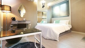 A modern hotel room with a glass desk, a bed with white bedding, a mounted deer head decoration, and a large window with blinds. - Number 25 Gongju Shingwan (Gongju)