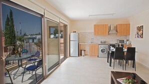 Een modern appartement met balkon, keuken en een eethoek.