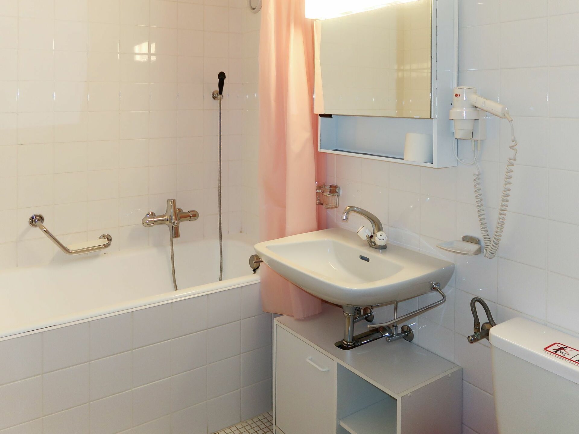 A bathroom with a bathtub, a sink, a shower, and a toilet.
