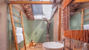 A bathroom with a large wooden vanity, a white sink, and a shower area with a wooden ladder. - Leopard Safaris Yala  (Kataragama)