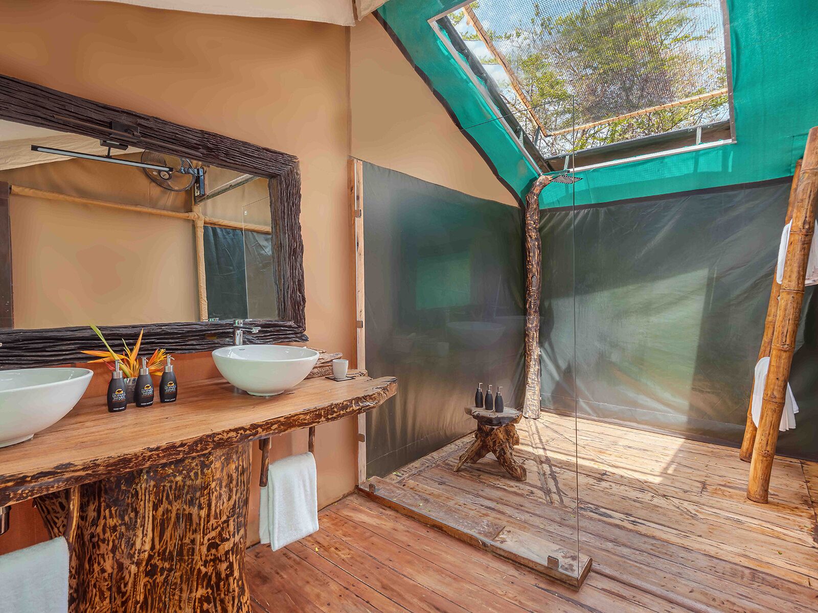 Une salle de bain dotée d’un grand miroir, de deux lavabos et d’un espace douche.