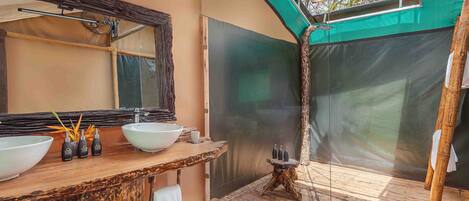 Une salle de bain dotée d’un grand miroir, de deux lavabos et d’un espace douche.