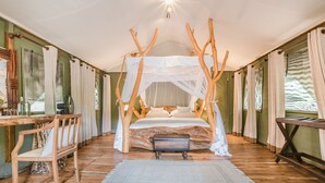 A room with a canopy bed, wooden furniture, and a view of the outdoors. - Leopard Safaris Yala  (Kataragama)
