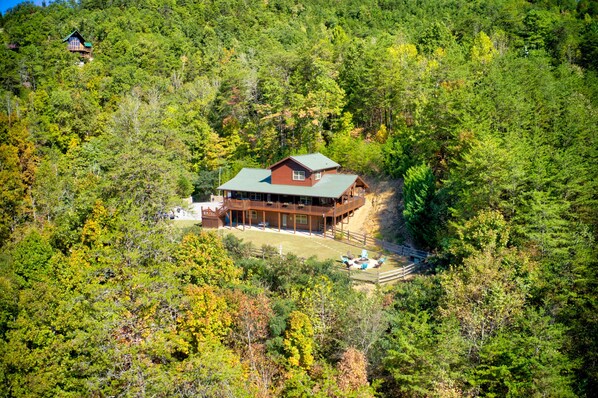 Ein geräumiges Blockhaus mit einer Terrasse, umgeben von dichtem Wald.