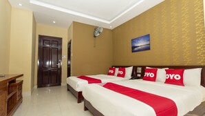 A hotel room with two beds, a wooden dresser, and a painting on the wall. - OYO 1067 Phuc Long Hotel (Da Nang)